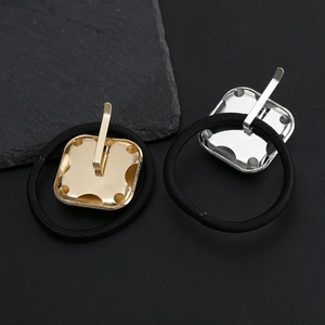 Minimalist square metal hair ties in gold and silver finish on black hair elastics