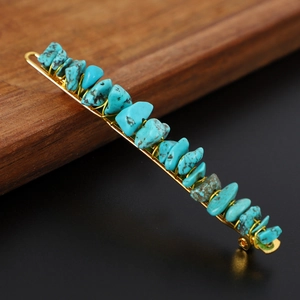 Close-up of bohemian turquoise stone hair clip with intricate gold wire wrapping detail