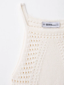 Macro detail of cream crochet halter neck dress showing knit texture and brand label