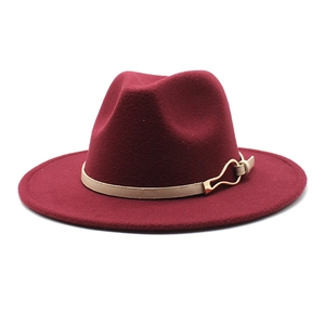 Détail d'un chapeau fedora bordeaux avec ruban beige et boucle en métal doré