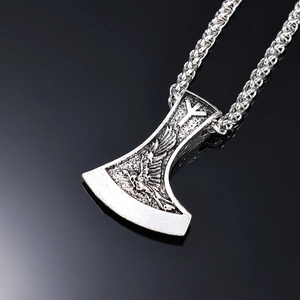 Detail of Viking battle axe pendant with eagle relief and runes on black reflection