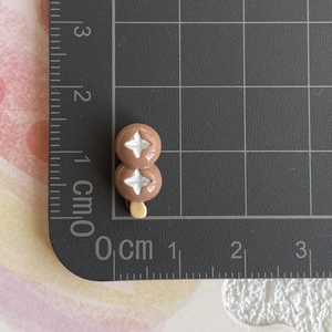 Miniature alimentaire dango en résine de 1,8 cm mesurée sur un tapis de coupe noir