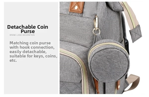 Detail of grey quilted diaper bag with detachable round coin purse and gold zippers
