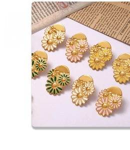 Flat lay view of 18k gold daisy earrings in white, pink, yellow, and green colors