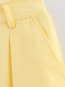 Macro shot of light yellow fabric texture featuring waist loop and side pocket details