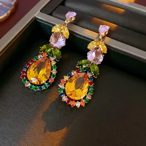 Macro shot of colorful teardrop zircon earrings in a premium dark jewelry gift box