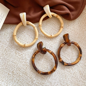 Detail of resin bamboo-style hoop earrings in light wood and dark tortoiseshell finish