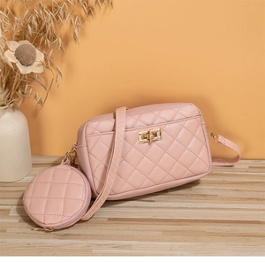 Detalle de bolso acolchado rosa con herrajes dorados y monedero redondo a juego