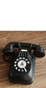 Close-up of vintage resin telephone model showing detailed dial on rustic wood surface