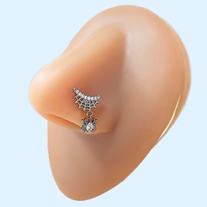 Macro shot of silver spider web nose stud with sparkling white zircons on a model