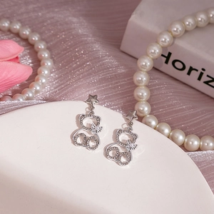 Gros plan détaillé de boucles d'oreilles ours en argent avec strass brillants et perles