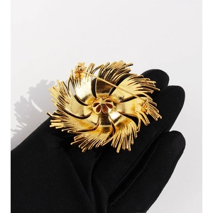Golden sunburst brooch in vintage flower design with high-quality polished finish