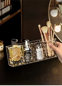 Detail of transparent acrylic makeup organizer with four compartments and water ripple texture