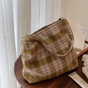 Détail du sac cabas en laine à carreaux avec étiquette simple wish sur table