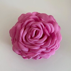 Detailed view of layered rose pink fabric flower clip with delicate chiffon petals