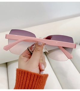 Detail of pink rimless sunglasses with purple gradient lenses and metal nose pads