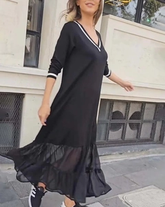 Détails du col en V rayé et de l'ourlet en mesh sur une robe mi-longue noire élégante