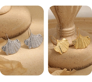Détail de boucles d'oreilles feuille de ginkgo en or et argent à texture brossée