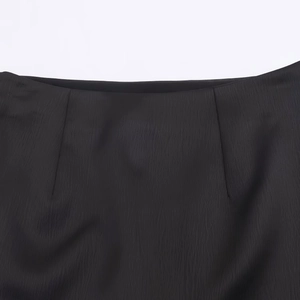 Gros plan détaillé du tissu noir lisse avec texture fine et couture précise à la taille
