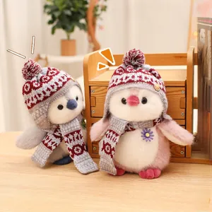 Detail of plush penguin toy set in grey and pink with knitted hats and scarves