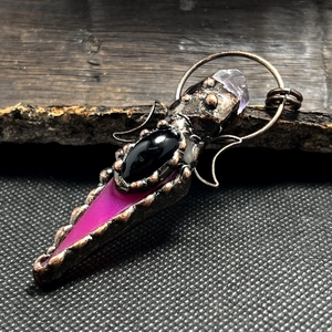Vintage bronze pendant with purple crystal agate and double moon arrows on wood background