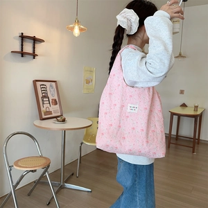 Close-up of pink quilted tote bag with floral pattern and soft fabric texture