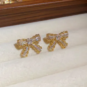 Elegant gold-plated bow earrings with cubic zirconia inlay in a jewelry box
