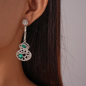 Détail d'une boucle d'oreille gourde en argent sertie d'émeraudes et de diamants
