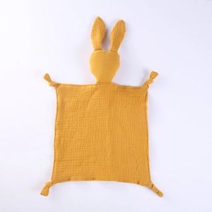 Détail d'un doudou lapin en gaze de coton jaune avec nœuds à mâcher pour les bébés