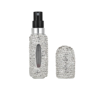 Silver rhinestone refillable perfume bottle with a clear viewing window on white background