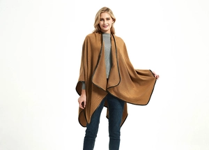 Detail of camel knit shawl featuring elegant black leather piping and buckle closure