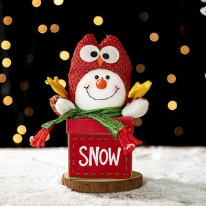 Christmas snowman gift box with red plush base and SNOW lettering in warm bokeh lighting