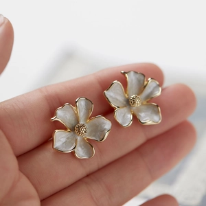 Dettaglio di eleganti orecchini a fiore di gelsomino bianco con bordi dorati