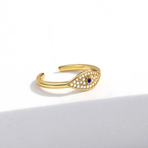 Detail of golden evil eye ring with blue gemstone and shimmering micro-set zircons