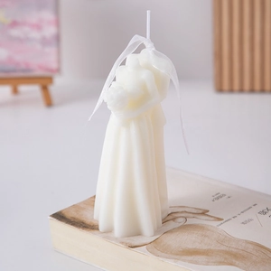 Detail of artistic bride and groom embrace scented candle with white silk ribbon
