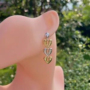 Détail de boucles d'oreilles cœur plaquées or 18 carats avec design à maillons mixtes