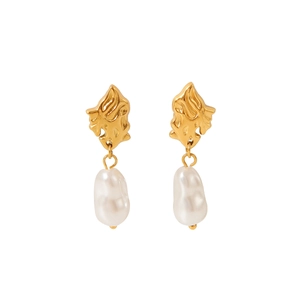 Détail de la texture métal lave dorée et de la perle baroque blanche sur boucles d'oreilles