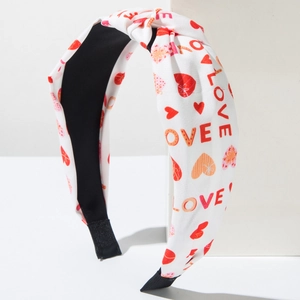 Detail of white knotted headband with red LOVE text and heart print on fabric