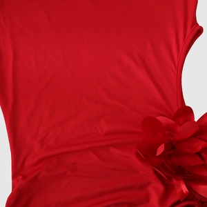 Detailed view of the red satin fabric and 3D floral decoration on the evening dress