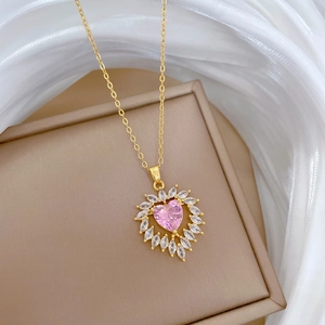 Elegant heart necklace with pink gemstone and clear crystals on a beige jewelry stand