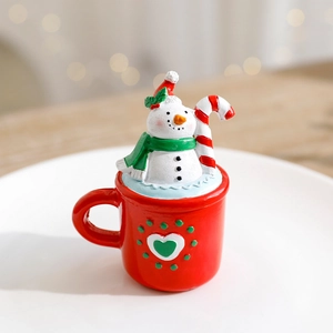 Miniature resin Christmas snowman figurine in a red teacup for holiday table decoration