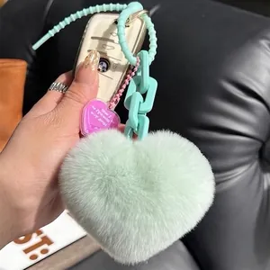 Mint green heart plush keychain with soft faux fur and chunky plastic chain on car keys