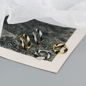 Close-up of twisted colorful enamel hoop earrings in gold and silver finishes