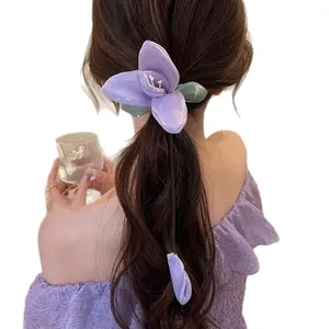 Elegant purple lily flower hair claw clip worn on a low ponytail hair style