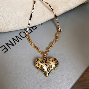 Leopard print heart pendant necklace with gold chain and textile rope stitching