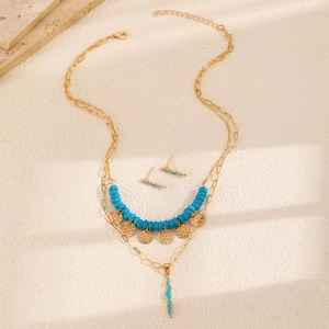Set collana a doppio strato e orecchini bohémien con perline blu su fondo sabbia