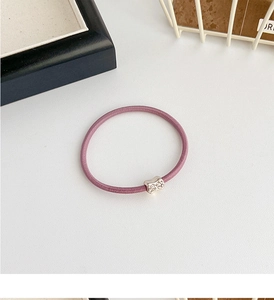 Close-up of purple high-elasticity hair tie featuring a sparkling rhinestone bow detail