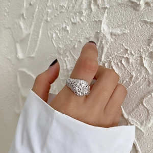 Minimalist S925 sterling silver wide ring with irregular hammered texture on model hand