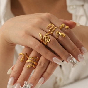 Detail of five 18K gold plated snake rings showing intricate scales and textured finish