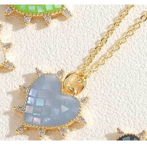 Vue macro de pendentifs en cœur avec incrustation mosaïque et bordure en cristal